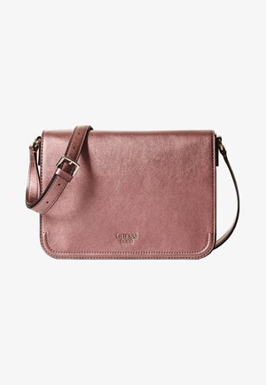 Metaliczna różowo-złota torebka na ramię z regulowanym paskiem i logo "GUESS 1981" na przedniej klapie, elegancki i prostokątny fason.