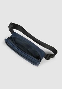 Marsupio in nylon blu navy con compartimento con cerniera, design piatto e tracolla regolabile nera. Texture liscia, stile minimalista.