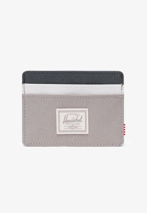 Tarjetero de tela gris con un panel superior gris oscuro, acento blanco y una etiqueta tejida. Cuenta con múltiples ranuras para tarjetas y una etiqueta a rayas rojas.