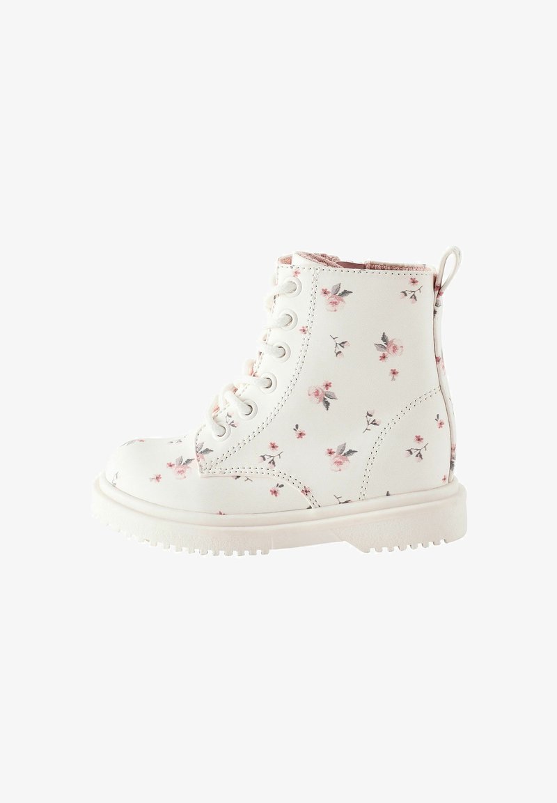 Bottine en simili cuir blanc avec imprimé floral rose et gris, à lacets sur le devant, semelle en caoutchouc texturée avec un passant au talon.