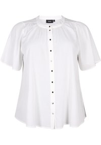 Blouse blanche à manches courtes avec col rond, tissu texturé, et une fermeture boutonnée à l'avant avec des boutons noirs et argentés.