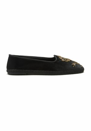 Scarpa nera piatta slip-on con perline dorate e decorazioni di gioielli sulla punta arrotondata e dettagli cuciti sulla suola.