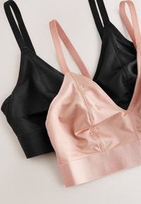 Deux brassières sans armatures en satin avec des bretelles réglables, une en rose doux et une en noir, posées à plat sur une surface claire.