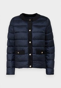 Navy puffer jacket with quilted texture, round neckline, front snap buttons, and two black fabric patch pockets with gold accents.