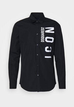 Chemise noire à boutons en coton, ornée d'un grand texte blanc "DSQUARED2 ICON" imprimé verticalement sur le côté gauche.