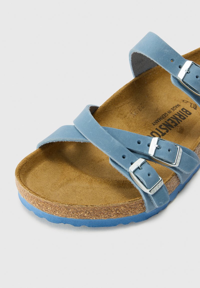 Blauwe leren sandaal met twee verstelbare banden en zilveren gespen, kurken voetbed en een gestructureerde lichtblauwe zool.