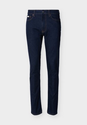 Dunkelblaue Slim-Fit-Jeans mit fünf Taschen, sichtbaren Nähten und Knopfverschluss an der Taille, vor einem schlichten Hintergrund präsentiert.