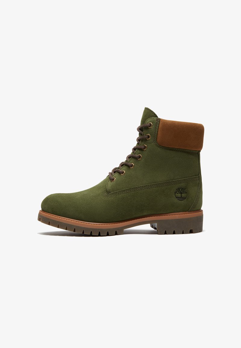 Stivale verde in camoscio con lacci, collo imbottito marrone, suola robusta e logo Timberland sul lato.