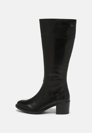 Les bottes noires montantes jusqu'aux genoux sont en cuir lisse, avec un bout arrondi et un talon carré. Leur design élégant se caractérise par des coutures réduites au minimum et des accents subtils.
