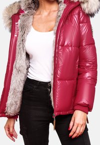 Giacca puffa di un rosa intenso con finitura lucida, foderata in pelliccia sintetica grigia, cappuccio e polsini elasticizzati; presenta tasche con zip e dettagli con logo.