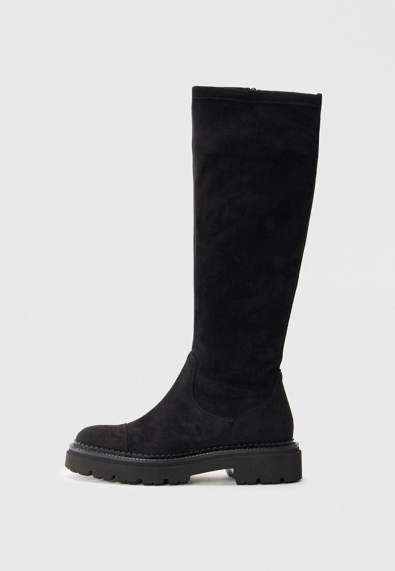 Juodi auliniai batai iki kelių, pagaminti iš zomšos, su apvaliu pirštu, tekstūruotu guminio pado ir paprastais siuvinėjimo elementais palei siūles.