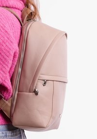 Light pink leather backpack featuring a textured finish, a front zip pocket with silver hardware, and minimalist design.