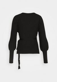 Pull en maille côtelée noire avec des manches longues et bouffantes, et un détail de taille à nouer. Il présente un col rond et une texture lisse sur un fond blanc.