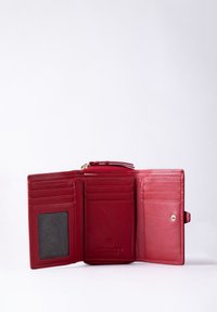 Red leather wallet with multiple card slots, a clear ID window, and a snap closure. Features smooth texture and embossed logo.