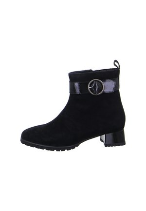 Black suede ankle boot with low block heel, shiny black strap, and circular silver buckle on outer side.