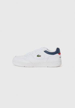 White leather sneaker with a round toe, lace-up design, navy and red accents on heel, green crocodile logo on the side, textured rubber sole.