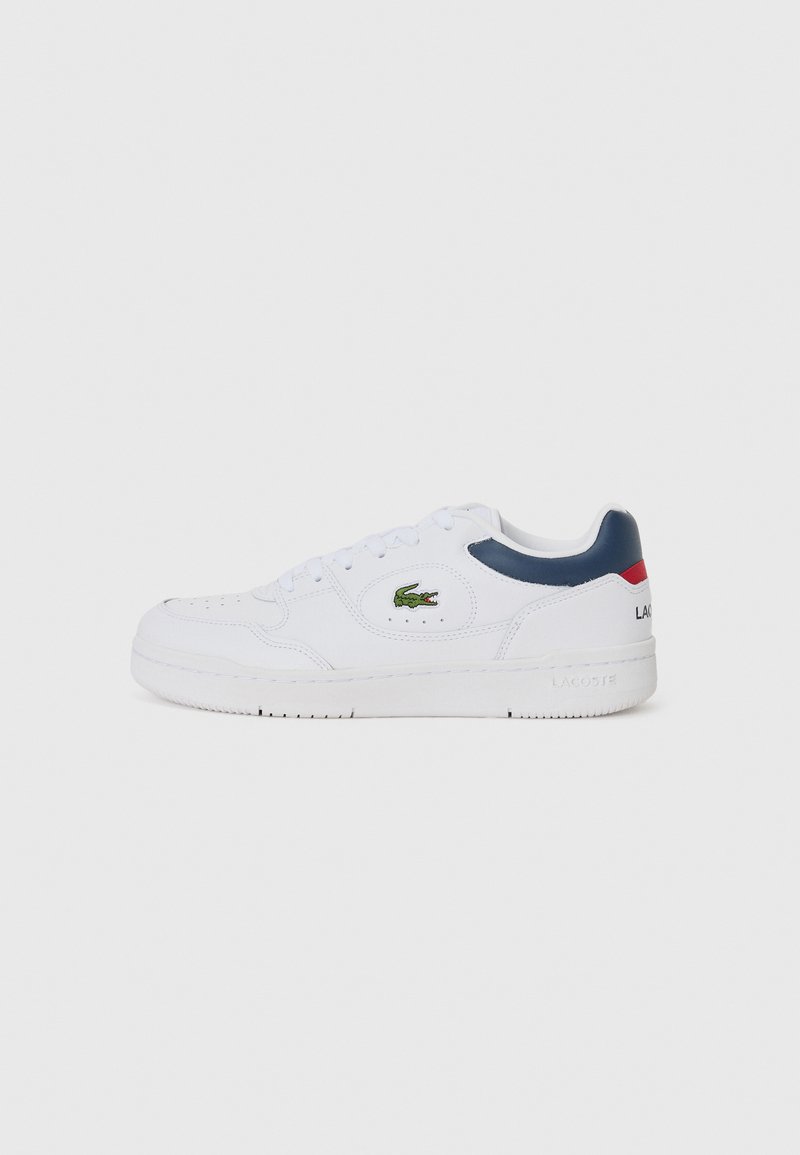 White leather sneaker with a round toe, lace-up design, navy and red accents on heel, green crocodile logo on the side, textured rubber sole.