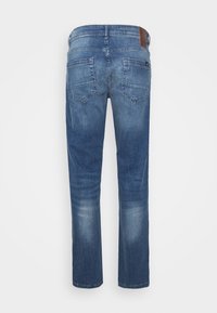 Los vaqueros de mezclilla azul presentan un diseño de pierna recta, dos bolsillos traseros y un detalle de cuero marrón en la cintura. Tela texturizada con un acabado desgastado.