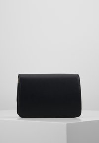 Borsa a mano in pelle nera con una texture liscia, forma rettangolare e chiusura a patta. Presenta dettagli in metallo color oro.