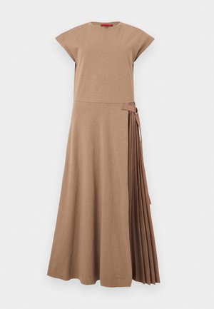Robe midi beige sans manches avec encolure ronde et panneau plissé sur le côté droit maintenu par une bride en tissu avec anneau en métal.