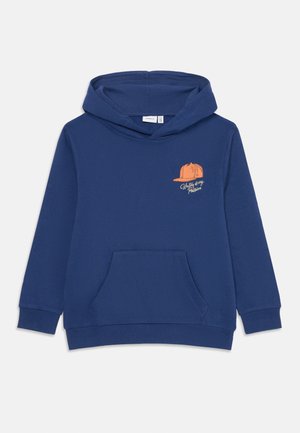 Mørkeblå barnehettegenser med frontlomme, ribbede mansjetter og liten oransje caps-grafikk med teksten "Skriving er min lidenskap" på brystet.