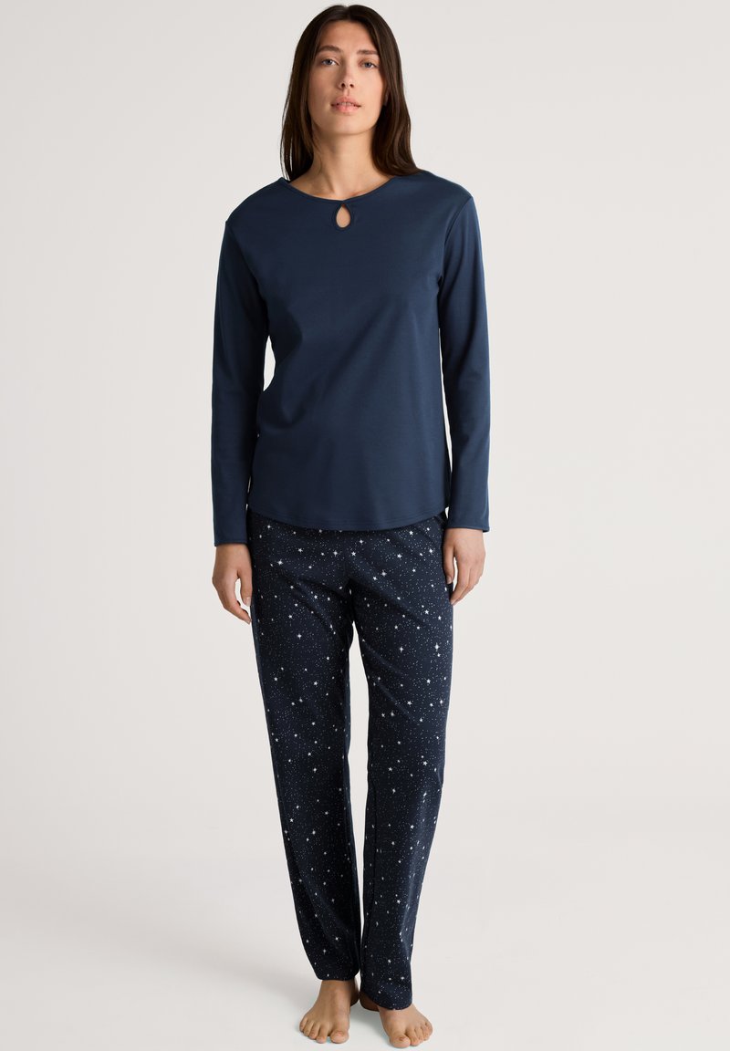 Navy long-sleeve top with a keyhole neckline paired with star-patterned pajama pants. Soft fabric and relaxed fit for comfort.