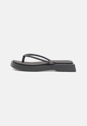 Black rubber flip-flop with a flat sole and a textured thong strap. The design features a slight elevation at the heel and a matte finish.