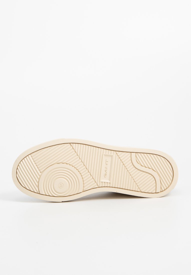 Helle beige Gummisohle mit strukturierten Mustern und Kurven; verfügt über kreisförmige und horizontale Rillen für Traktion und Halt.