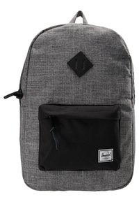 Zaino in tessuto grigio con finitura testurizzata, tasca frontale nera e toppe nere a forma di diamante. Presenta spallacci regolabili e chiusura con zip.