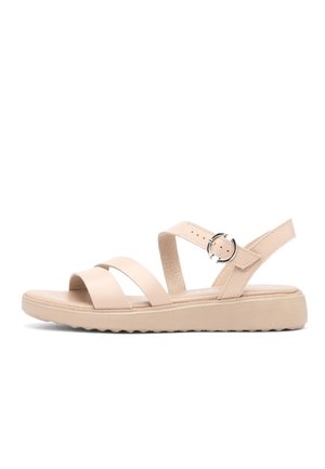 Beżowa płaska sandałka z dwoma paskami z przodu, paskiem na kostkę z okrągłą srebrną klamrą oraz miękką podeszwą z teksturowanym spodem dla lepszej przyczepności.