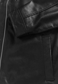 Black leather jacket featuring a textured surface, a zippered front, and a sleek design with a side pocket and cuff detail.