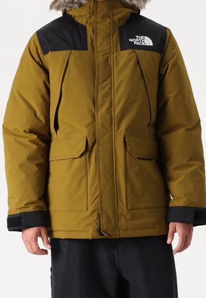 Isolerad parka i olivgrön med svarta detaljer. Har en avtagbar huva med pälskant, två framfickor och kardborrefästen vid ärmarna.