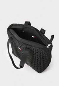 Borsa tote nera trapuntata con un esterno testurizzato, dotata di due manici, di un compartimento con zip e di una tasca interna.