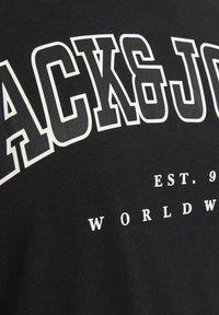 T-shirt en coton noir avec un grand texte blanc "BLACK&JOE" et "EST. 99" ainsi que "WORLDWIDE" imprimés en plus petite taille en dessous.