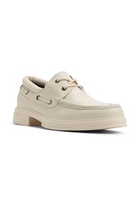 Beige läderbåtsko med rund tå, snörning framtill och texturerad yta. Har en minimalistisk design och en tjock gummisula.