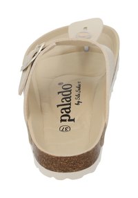 Light beige slip-on sandal with a cork base and white outsole. Features an adjustable strap with a circular hardware detail. Interior branding printed.