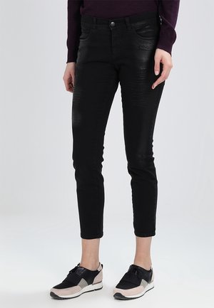 Jeans de mezclilla negra con un ajuste Slim, cintura de media altura, diseño de cinco bolsillos y sutiles acentos texturizados en la tela.