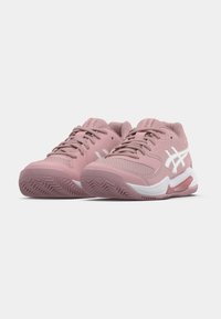 Różowe buty sportowe z siateczkową cholewką i białymi akcentami. Posiadają teksturowaną podeszwę i wyściełany kołnierz dla wsparcia. Płaskie sznurowadła i wzmacniany nosek.
