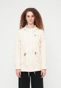 Veste beige clair avec capuche, dotée de poches avant, d'une taille ajustable par cordon et de détails à fermeture éclair. Tissu lisse avec un design simple et fonctionnel.