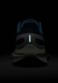 Chaussure de course sombre avec tige en maille, accents en teal, détail réfléchissant au talon et semelle intercalaire grise contrastante. Ajustement près du pied avec une finition texturée.