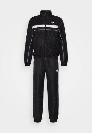 Black tracksuit made of smooth, shiny fabric. Jacket features white stripes and a zippered front. Pants have elastic cuffs and matching logo.
