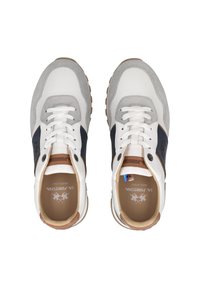 Witte en grijze sneakers met marineblauwe accenten, gemaakt van leer en suède, met ronde veters en een rubberen zool. Logo op de tong. Ontworpen voor comfort.