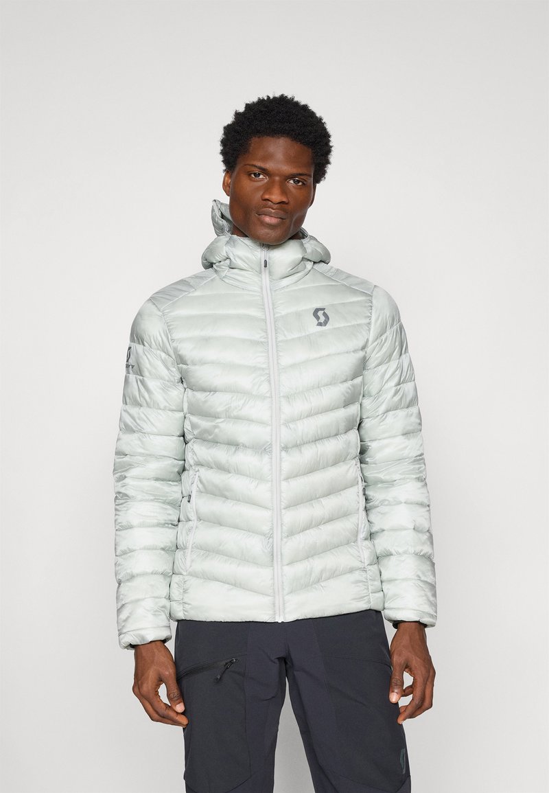 Jasnoszara ocieplana kurtka z zamkiem z przodu, z ribbowanym teksturem i kapturem. Posiada boczne kieszenie oraz logo na klatce piersiowej i rękawie.