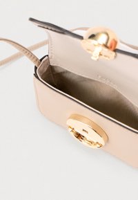 Τσάντα χειρός από δέρμα σε ταμπά χρώμα με χρυσό κλείστρο. Διαθέτει λεία επιφάνεια εξωτερικά και εσωτερικό επενδυμένο με σατέν, παρουσιάζοντας έναν συμπαγή, ορθογώνιο σχεδιασμό.