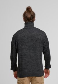 Chunky mørkegrå turtleneck sweater med ribbede ærmer og en blød tekstur, der har en let afslappet pasform og et casual design.