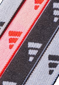 Drei Stoffbänder in Pink, Schwarz und Weiß mit einem wiederholten dreieckigen Muster und kontrastierenden Farben entlang der Ränder.