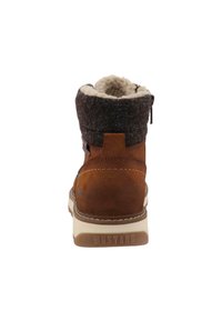 Stivaletto in pelle scamosciata marrone con risvolto in maglia grigia, foderato in pelliccia sintetica e suola in gomma bianca. Presenta chiusura con cerniera e marchio "MUSTANG".