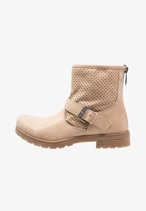 Beige nilkkasaapas jossa on rei'itetty yläosa, sivulla solkikiinnitys, pyöreä kärki, vetoketju takana ja matala kerrostettu kantapää uritetulla pohjalla.