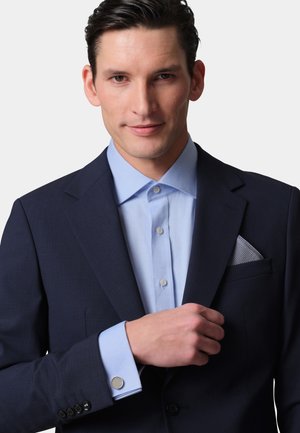 Navy suit jacket with a light blue shirt, featuring a textured pocket square and cufflinks; smooth fabric, structured design, and modern look.