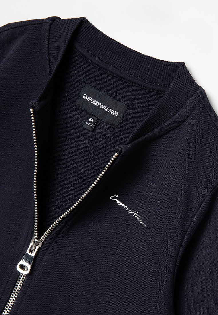 Giacca zip-up blu navy realizzata in tessuto morbido con colletto a coste. Caratterizzata da una cerniera argentata e logo del marchio ricamato sul davanti.